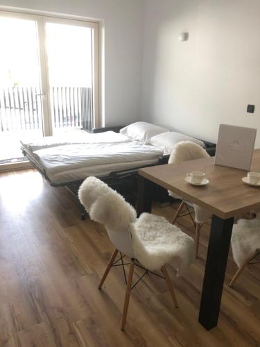 um quarto com uma cama, duas cadeiras e uma mesa em VILA Mojca - APARTMENT PERIDOT - Center em Kranjska Gora