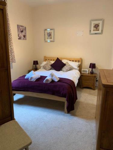 a bedroom with a bed with two towels on it at Postman's Knock, Lynmouth, first floor apartment with private parking in Lynmouth