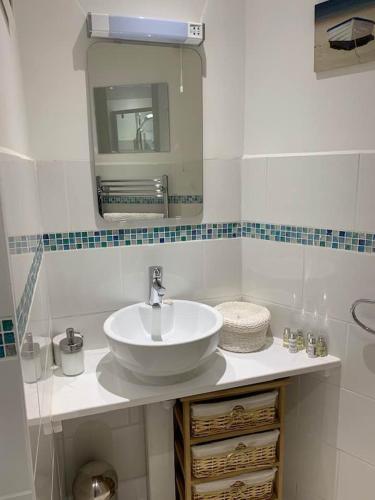 a bathroom with a white sink and a mirror at Postman's Knock, Lynmouth, first floor apartment with private parking in Lynmouth