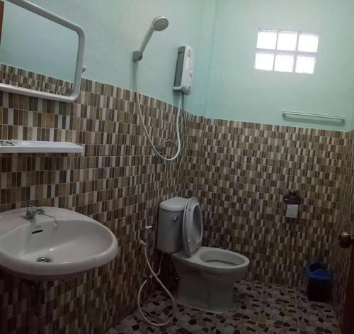 een badkamer met een wastafel, een toilet en een douche bij Phu Chaem House in Mae Chaem