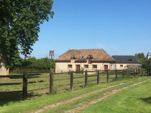 une vieille maison dans un champ avec une clôture dans l'établissement Le Domaine d'Olène, au Pin