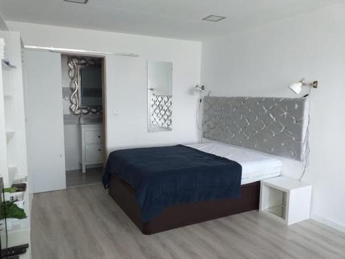 a white bedroom with a bed with a blue blanket at AP TORRE in Torre de Moncorvo
