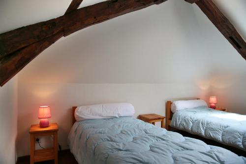 2 camas en una habitación con 2 lámparas en las mesas en GITE LA TENGNE en Parnac