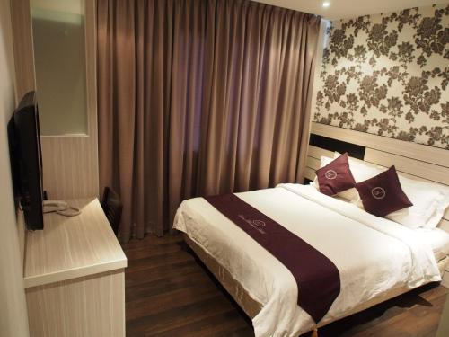 a bedroom with a bed and a television in it at Venus Boutique Hotel in Melaka