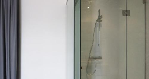 a shower with a glass door with a shower at Hotel Grecale in Porto Cesareo