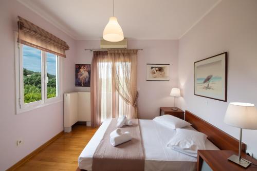 a bedroom with two beds and a window at Violet Luxury Villa in Lefkada Town