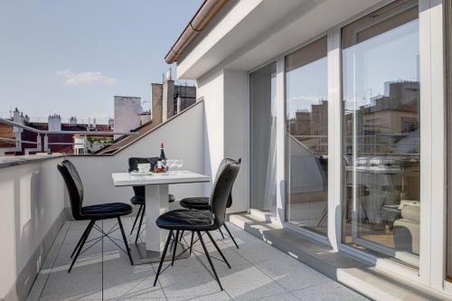 a balcony with a table and chairs on a building at Gold Art Apartments in Prague