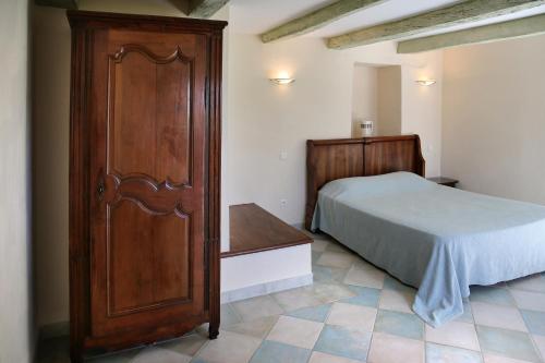 1 dormitorio con 1 cama y armario de madera en EARL DOMAINES DELMAS en Parnac