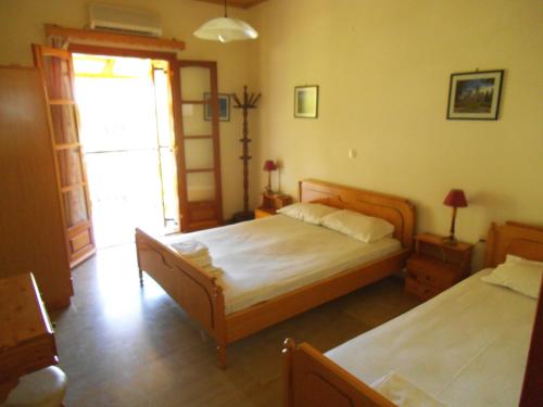 a bedroom with two beds and a window at Villa Xenos in Kalamaki