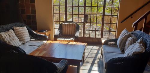 a living room with couches and a coffee table at Milorho Lodge in Rietfontein