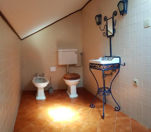 a bathroom with a toilet and a sink in it at Casa Dona Beatriz in Furnas