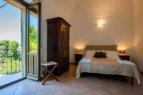 a bedroom with a bed and a large window at Il Carmine Dimora Storica in Erice