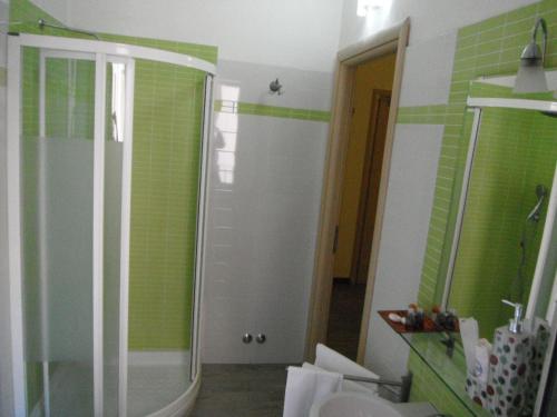 a bathroom with a shower with green tile at Hotel Renato in Sesto San Giovanni