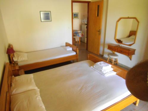 a hotel room with two beds and a mirror at Villa Xenos in Kalamaki