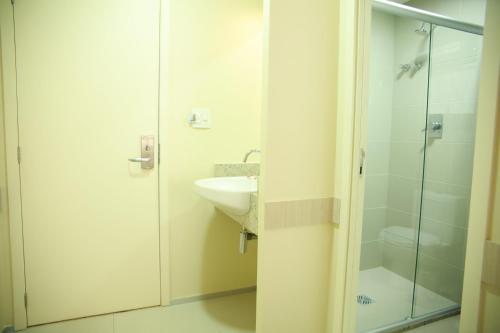 uma casa de banho com um lavatório e uma cabina de duche em vidro. em Stay Inn Hotel em Imperatriz