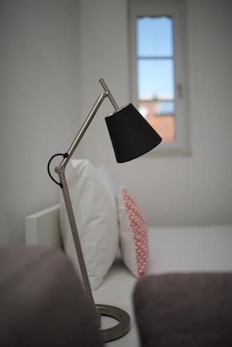 a lamp sitting on a couch next to a pillow at Apartments and Rooms Jospino in Mali Lošinj