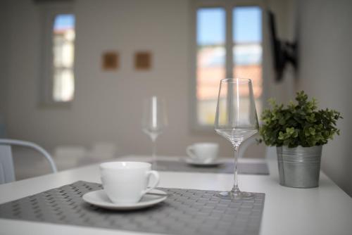 a table with a cup and a wine glass on it at Apartments and Rooms Jospino in Mali Lošinj