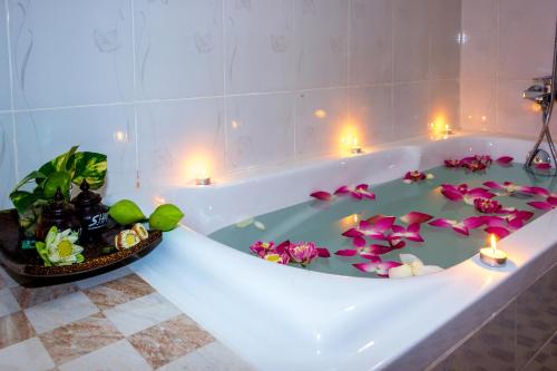 uma banheira com velas e flores em The Siem Reap Chilled Backpacker em Siem Reap