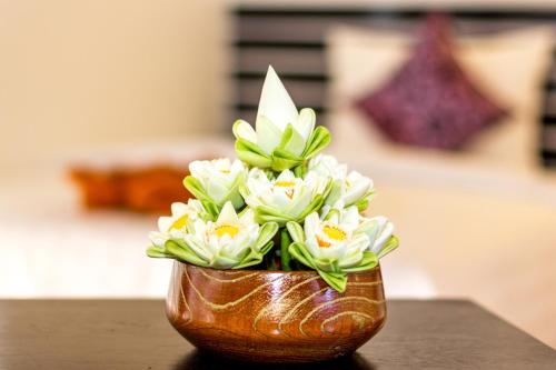 a vase filled with white flowers on a table at The Siem Reap Chilled Backpacker in Siem Reap