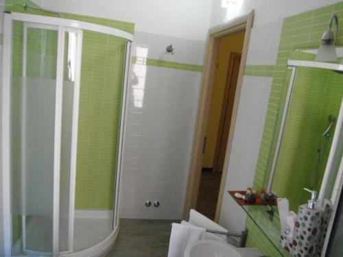 a bathroom with a shower with green tiles on the wall at Hotel Renato in Sesto San Giovanni