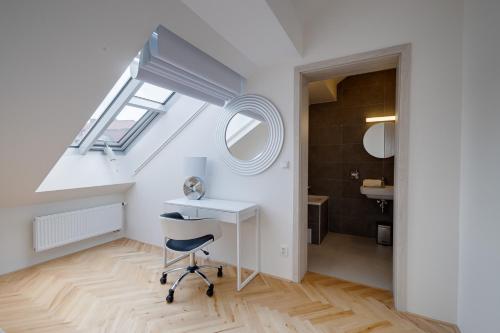 a desk and a chair in a room with a bathroom at Gold Art Apartments in Prague
