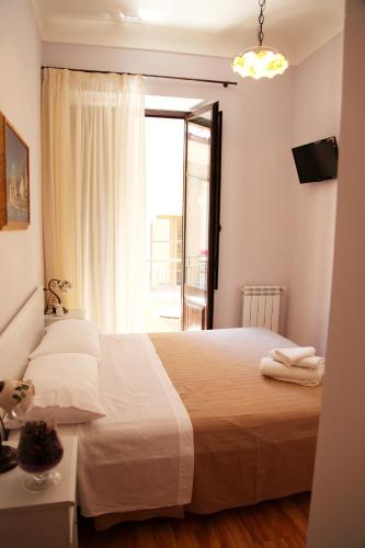 a bedroom with a large bed and a window at Bed & Breakfast Duomo Di Taormina in Taormina