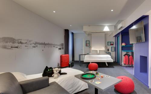 - une chambre avec un lit, une table et un canapé dans l'établissement ibis Styles Nantes Centre Gare, à Nantes
