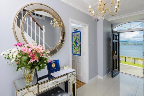 a vase of flowers on a table in a room with a mirror at Harbour View in Kenmare