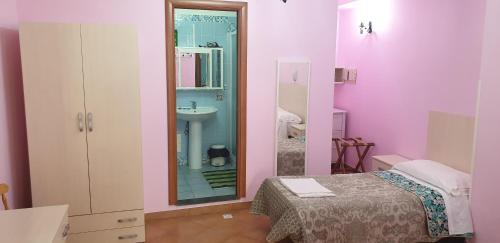 a room with a bed and a sink and a mirror at Agriturismo Piccolo Paradiso in Piano di Sorrento
