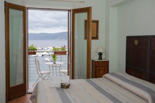 a bedroom with a bed and a view of a balcony at La Sciabica in Scilla