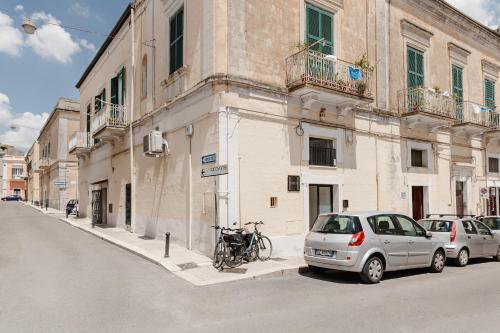two cars parked in front of a building on a street at Hydria Rooms in Matera