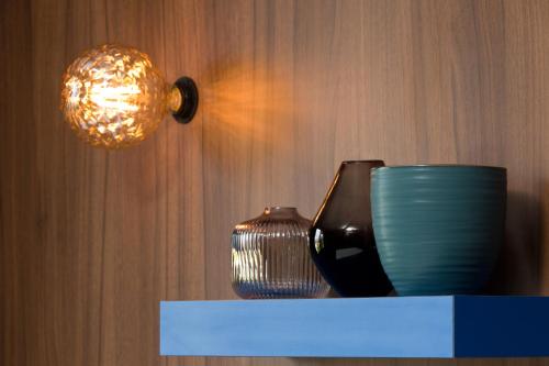 two vases sitting on a shelf next to a light at Hôtel Montmorency & Spa in Carcassonne