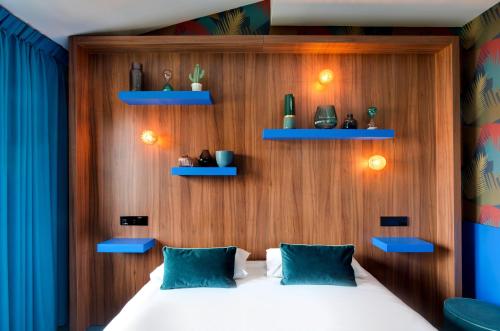 a bedroom with a bed with blue shelves at Hôtel Montmorency & Spa in Carcassonne