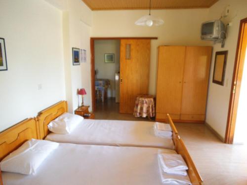 a bedroom with two beds and a hallway at Villa Xenos in Kalamaki