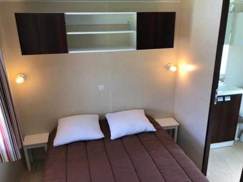 - une chambre avec un lit et 2 oreillers blancs dans l'établissement LE MEDOC AUX 4 VENTS, à Jau-Dignac-et-Loirac