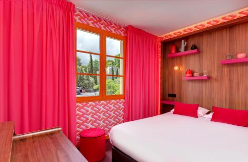 a bedroom with red curtains and a bed and a window at Hôtel Montmorency & Spa in Carcassonne