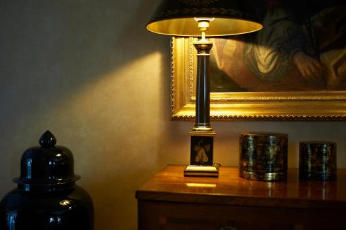 a lamp sitting on a table next to a painting at Hotel Real Palacio in Lisbon
