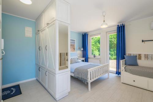 a bedroom with a bed and a large white cabinet at Błękitne Zacisze in Sztutowo