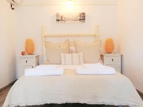 a bedroom with a white bed with two night stands at Finca Gran Cerros in Alora