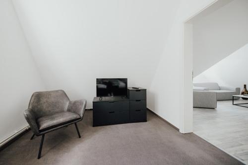 a living room with a chair and a television at Magni Boutique Hotel in Braunschweig