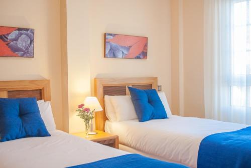 two beds in a room with blue and white at Ona Ogisaka Garden in Denia
