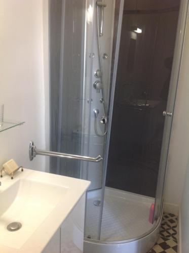 une douche avec une porte vitrée à côté d'un lavabo dans l'établissement Le Gros Chigy Château, à Saint-André-le-Désert