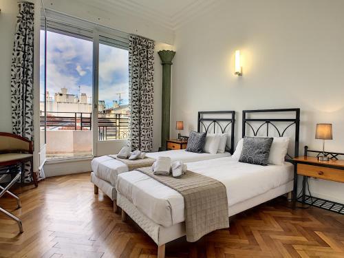 une chambre avec deux lits et une grande fenêtre dans l'établissement Nestor&Jeeves - SEA VIEW TERRACE PENTHOUSE - Exceptional terrace - Top floor, à Nice