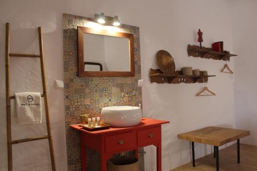a bathroom with a sink and a mirror on a table at Monte de Portugal in Montargil