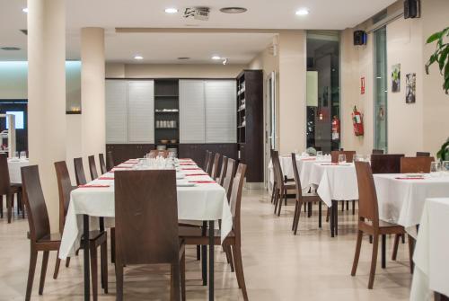 a dining room with white tables and chairs at Ona Ogisaka Garden in Denia