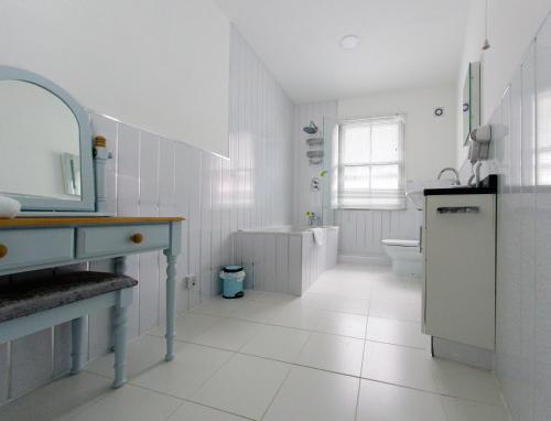 a bathroom with a sink and a tub and a toilet at Three Queens Hotel in Burton upon Trent