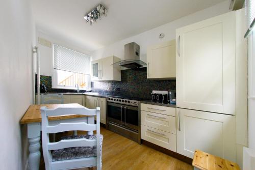 a kitchen with white cabinets and a stove top oven at Three Queens Hotel in Burton upon Trent
