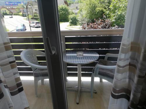 uma mesa e cadeiras numa varanda com uma janela em Haus Alexis em Faak am See