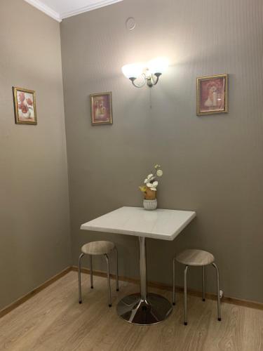 a white table and two stools in a room at Rocca Apartments in Tallinn