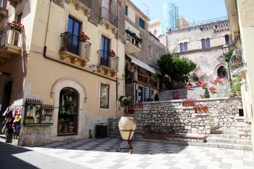 a city street with buildings and a bucket on the sidewalk at Bed & Breakfast Duomo Di Taormina in Taormina